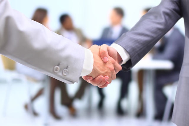 Two successful businessman shaking hands in front