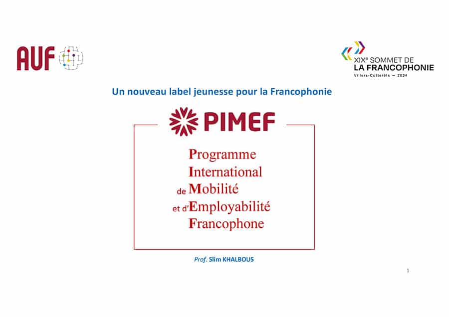 Deux personnes assises à une table dans ce qui semble être un espace intérieur. La personne à l'avant est une femme souriante. Elle semble très engagée dans la conversation, son visage rayonne de joie. La personne en arrière-plan est de dos, elle semble également engagée dans la discussion. L'ambiance générale semble être détendue et amicale.